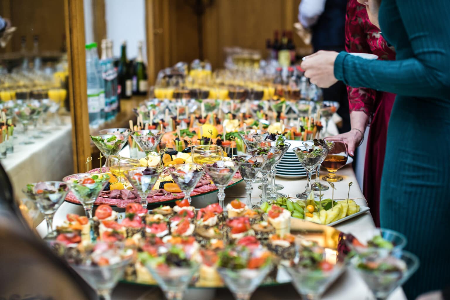 The girl chooses a dish at the buffet table with snacks, restaurant