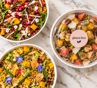Three vibrant salads in bowls, perfect for Climate Week NYC catering, with colorful veggies and a gluten-free container.